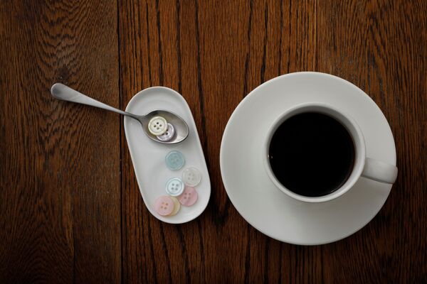 الأزرار البلاستيكية التي تزن 5 غرامات، أي ما يعادل كمية البلاستيك التي يمكن أن يأكلها شخص ما في أسبوع واحد، تُعرض مع فنجان من القهوة في هذا الرسم التوضيحي الذي تم التقاطه في طوكيو، اليابان 31 مارس 2020 - سبوتنيك عربي