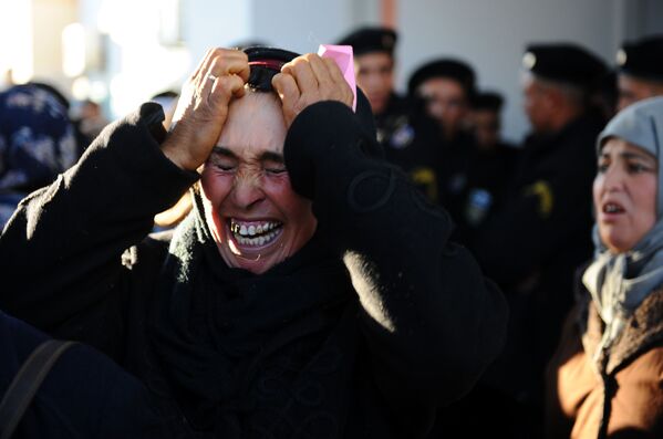 امرأة تبكي أمام مبنى المحافظة وهي تنتظر مع أشخاص آخرين لمقابلة المحافظ في سيدي بوزيد، تونس  10 يناير 2011  - سبوتنيك عربي