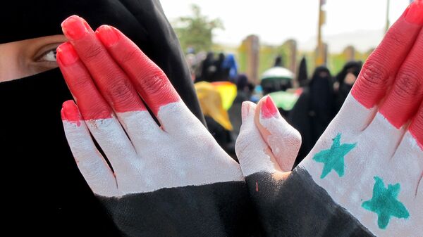 امرأة تظهر كفة يدها المرسوم عليها ألوان العلمين اليمني والسوري خلال مظاهرة حاشدة ضد حكم الرئيس علي عبد الله صالح في العاصمة اليمنية صنعاء، 4 نوفمبر 2011 - سبوتنيك عربي