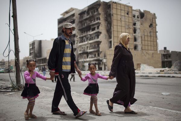 عائلة تسير في شارع طرابلس، مركز القتال بين قوات المعارضة الليبية وقوات معمر القذافي في مصراتة، 22 مايو 2011 - سبوتنيك عربي