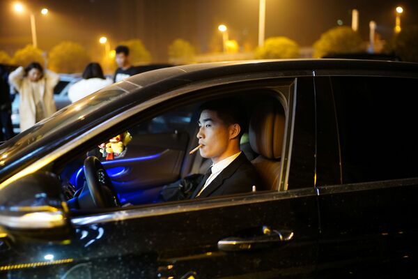 رجل يقود سيارة خارج ملهى ليلي، بعد عام تقريبًا من التفشي العالمي لمرض فيروس كورونا (كوفيد-19) في ووهان، مقاطعة هوبي، الصين، 12 ديسمبر 2020. - سبوتنيك عربي