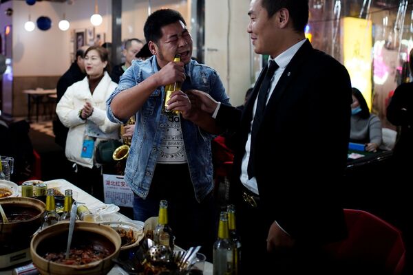 الناس في مطعم في أحد شوارع المدينة ليلاً، بعد عام تقريبًا من تفشي مرض فيروس كورونا (كوفيد-19) في ووهان، مقاطعة هوبي، الصين 11 ديسمبر 2020 - سبوتنيك عربي