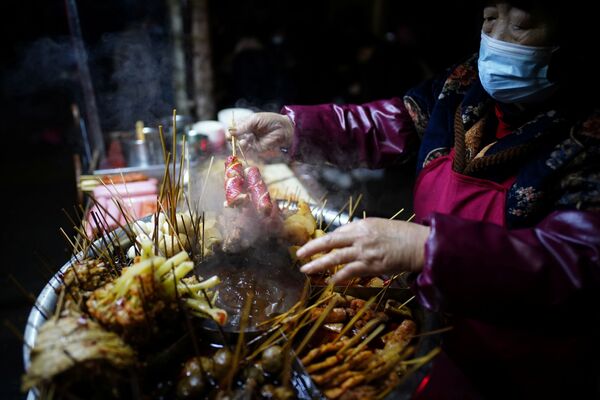 بيع وجبات خفيفة وسريعة في أحد شوارع ووهان، بعد عام تقريبًا من تفشي مرض فيروس كورونا (كوفيد-19)، مقاطعة هوبي، الصين 11 ديسمبر 2020 - سبوتنيك عربي