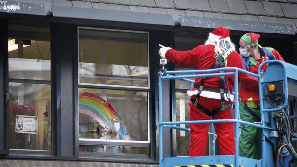 الوضع في بريطانيا مع ظهور سلالة كورونا الجديدة - رجال يرتدون زي بابا نويل ويحيون مرضى مستشفى ليدز للأطفال، إنجلترا 21 ديسمبر 2020 - سبوتنيك عربي