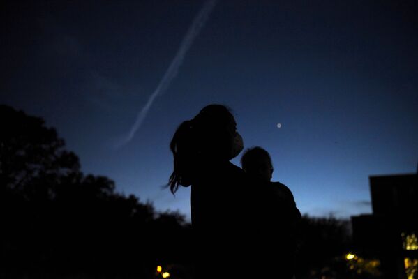 أشخاص يراقبون كوكبي زحل والمشتري في السماء، فوق هيوستن، بولاية تكساس في الولايات المتحدة 21 ديسمبر 2020 - سبوتنيك عربي