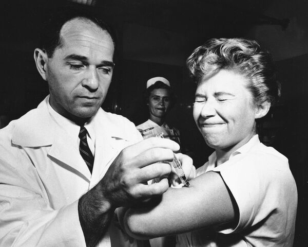 تظهر هذه الصورة الارشيفية التي التقطت في 16 أغسطس 1957، الدكتور جوزيف بالينجر وهو يعطي مارجوري هيل، الممرضة في مستشفى مونتيفيوري في نيويورك، أول لقاح مضاد للأنفلونزا الأسيوية (جائحة  1957-1958) يتم إعطاؤه في مدينة نيويورك الأمريكية. - سبوتنيك عربي