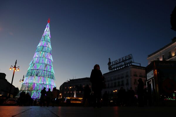 الناس يتجمعون حول شجرة عيد الميلاد في ساحة بويرتا ديل سول، وسط جائحة فيروس كورونا (كوفيد-19) في مدريد، إسبانيا 2 ديسمبر 2020 - سبوتنيك عربي