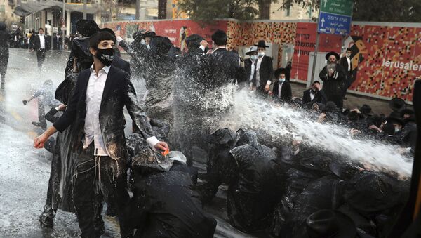 أطلقت الشرطة الإسرائيلية خراطيم المياه باتجاه اليهود المتدينين، الذين أغلقوا الطريق خلال مظاهرة في القدس، 22 ديسمبر 2020. - سبوتنيك عربي