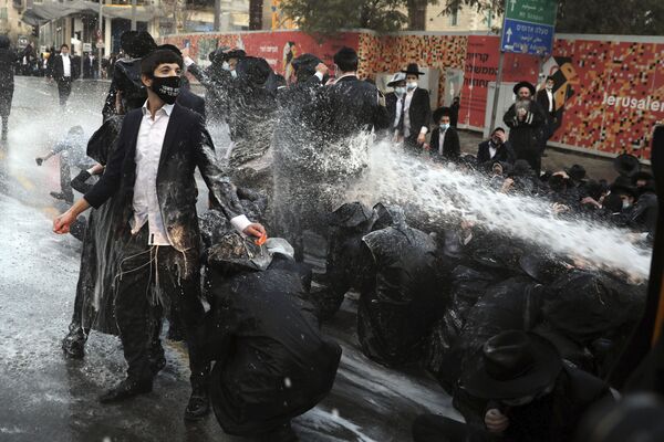 أطلقت الشرطة الإسرائيلية خراطيم المياه باتجاه اليهود المتدينين، الذين أغلقوا الطريق خلال مظاهرة في القدس، 22 ديسمبر 2020. - سبوتنيك عربي