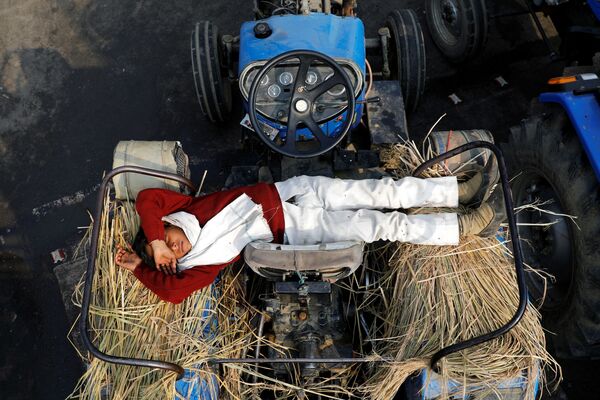 نجل مزارع ينام على جرار في موقع احتجاجات ضد قوانين الزراعة الجديدة، عند حدود دلهي وأوتار براديش في غازي آباد، الهند، 23 ديسمبر 2020 - سبوتنيك عربي