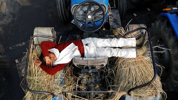 نجل مزارع ينام على جرار في موقع احتجاجات ضد قوانين الزراعة الجديدة، عند حدود دلهي وأوتار براديش في غازي آباد، الهند، 23 ديسمبر 2020 - سبوتنيك عربي
