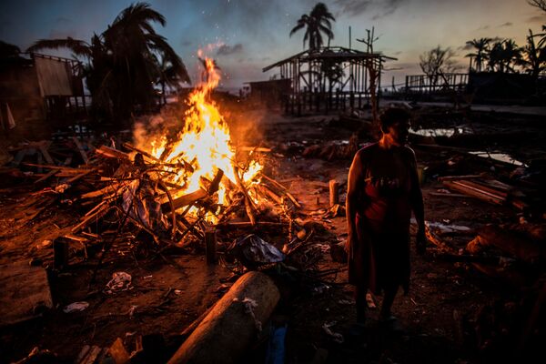 الناس يحرقون الحطام من منازلهم في بيلوكسي، في منطقة شمال البحر الكاريبي المتمتعة بالحكم الذاتي، نيكاراغوا، 27 نوفمبر 2020، بعد أيام من مرور إعصار إيوتا - سبوتنيك عربي