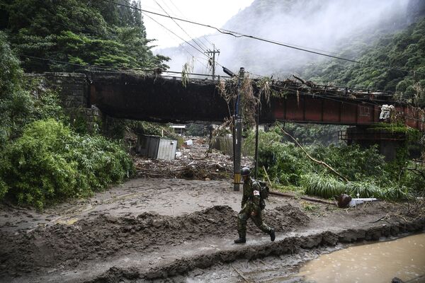 جندي من قوات الدفاع الذاتي اليابانية (JSDF) يسير في منطقة ضربتها السيول في أشيكيتا، محافظة كوماموتو، اليابان 7 يوليو 2020 - سبوتنيك عربي