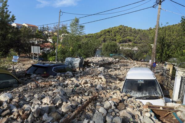السيارات مغطاة بالصخور في أعقاب عاصفة يانوس في قرية أسوس بجزيرة كيفالونيا الأيونية غربي اليونان، 20 سبتمبر 2020 - سبوتنيك عربي