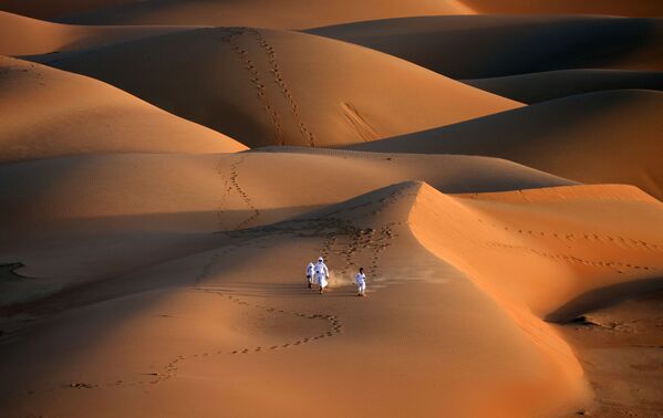 شبان إماراتيون خلال تدريب الصقور في صحراء ليوا، على بعد حوالي 250 كيلومترا غرب إمارة أبو ظبي الخليجية، 9 يناير 2021 - سبوتنيك عربي