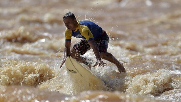 راكب الأمواج البرازيلي باولو غويدو على نهر دوسي في محافظة غوفيرنادور فالاداريس، البرازيل، 9 يناير 2021 - سبوتنيك عربي