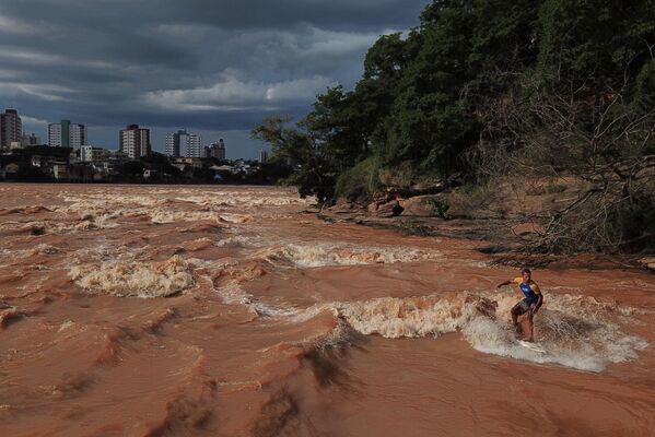 راكب الأمواج البرازيلي باولو غويدو على نهر دوسي في محافظة غوفيرنادور فالاداريس، البرازيل، 9 يناير 2021 - سبوتنيك عربي