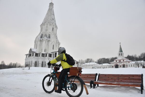شاب يركب دراجة بالقرب من كنيسة صعود الرب في حديقة كولومينسكويه في موسكو، 12 يناير 2020 - سبوتنيك عربي