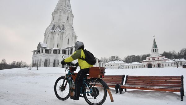 شاب يركب دراجة بالقرب من كنيسة صعود الرب في حديقة كولومينسكويه في موسكو، 12 يناير 2020 - سبوتنيك عربي