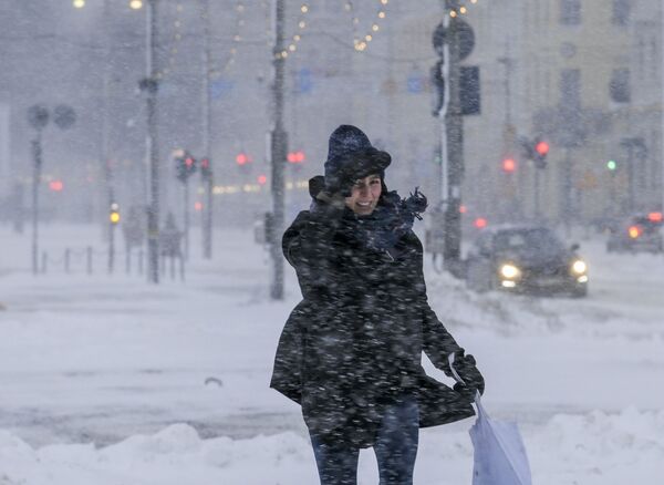 أحد المشاة يسير عبر طبقة سميكة من الثلج تغطي شوارع مدينة هلسنكي، فنلندا، 12 يناير 2021. - سبوتنيك عربي