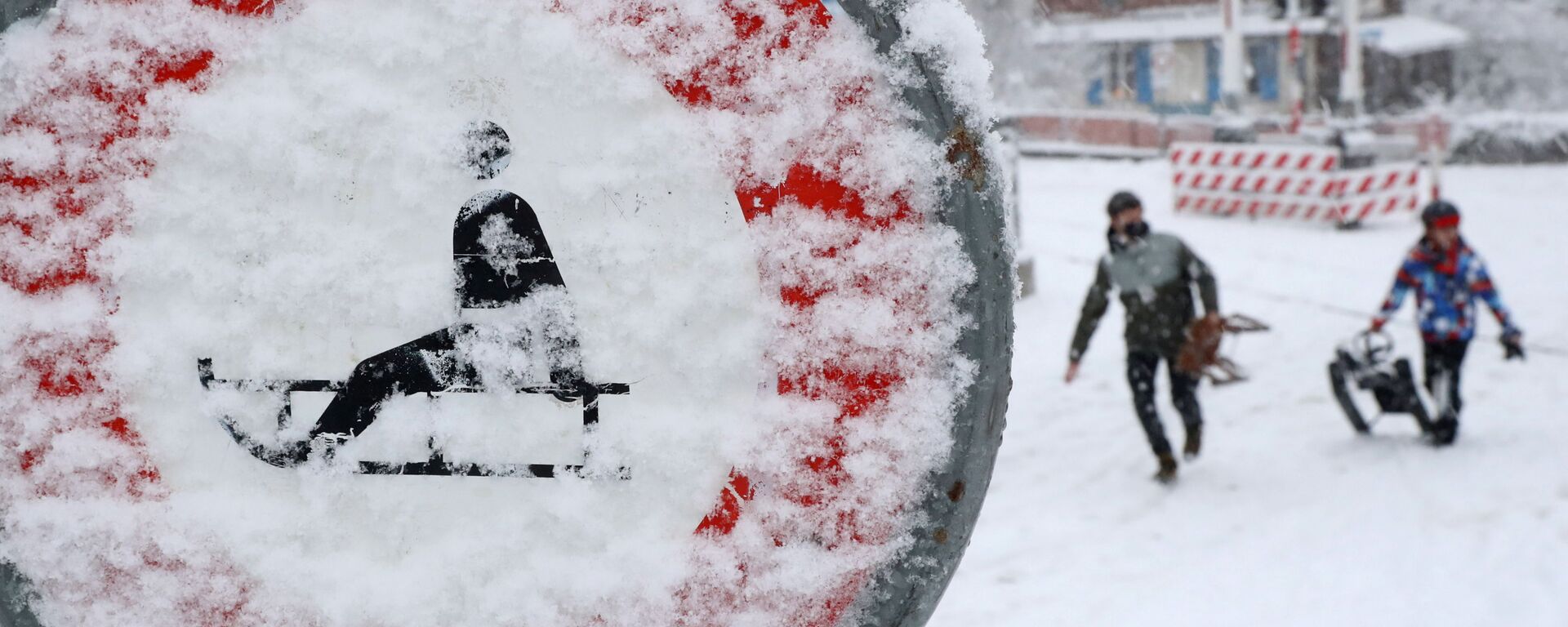 أشخاص يحملون زلاجات يسيرون أمام لافتة مرور مغطاة بالثلوج، مع استمرار انتشار فيروس كورونا (كوفيد-19) في زيورخ، سويسرا، 12 يناير 2021 - سبوتنيك عربي, 1920, 20.01.2021