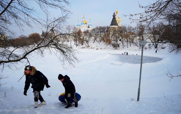 أطفال يمرحون على بحيرة متجمدة بالقرب من دير نوفوسباسكي في موسكو، 13 يناير 2021 - سبوتنيك عربي