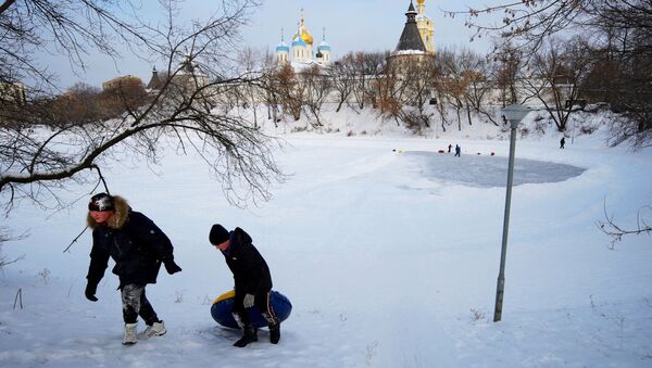 أطفال يمرحون على بحيرة متجمدة بالقرب من دير نوفوسباسكي في موسكو، 13 يناير 2021 - سبوتنيك عربي