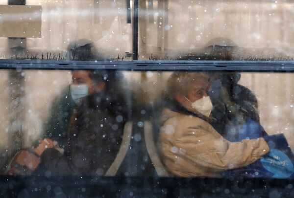 أشخاص يرتدون كمامات للوقاية من فيروس كورونا يجلسون على متن حافلة في بلغراد، صربيا،11 يناير 2021.  - سبوتنيك عربي