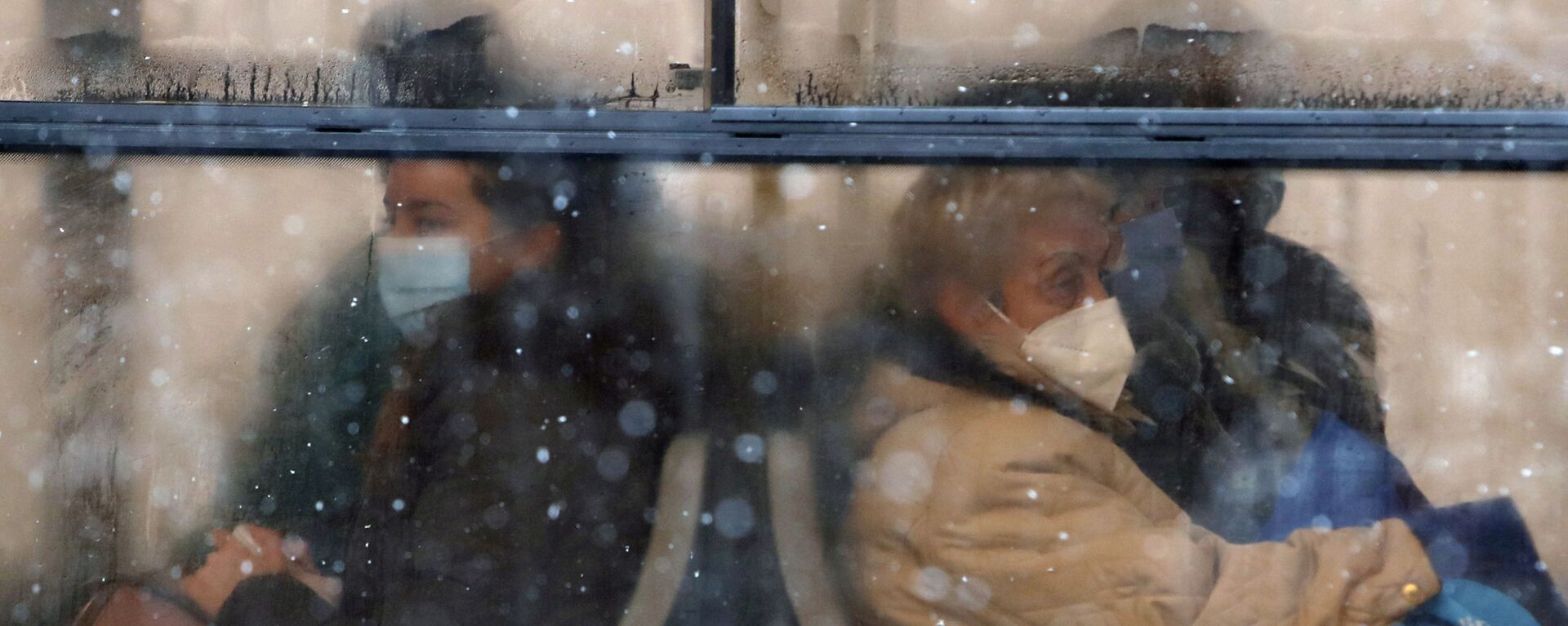 أشخاص يرتدون كمامات للوقاية من فيروس كورونا يجلسون على متن حافلة في بلغراد، صربيا،11 يناير 2021.  - سبوتنيك عربي, 1920, 09.11.2021