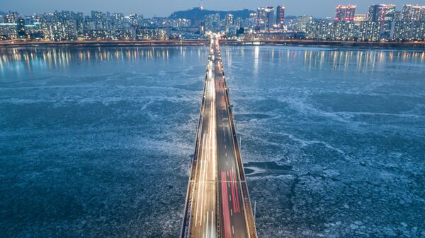 تُظهر صورة تم التقاطها في 10 يناير 2021 منظرًا عامًا لحركة المرور التي تمر فوق جسر فوق نهر هان المتجمد على خلفية مدينة سيئول، كوريا الجنوبية 10 يناير 2021 - سبوتنيك عربي