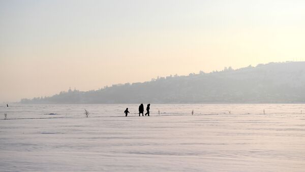 امرأة وأطفال يسيرون على جليد نهر الفولغا، روسيا 13 يناير 2021 - سبوتنيك عربي