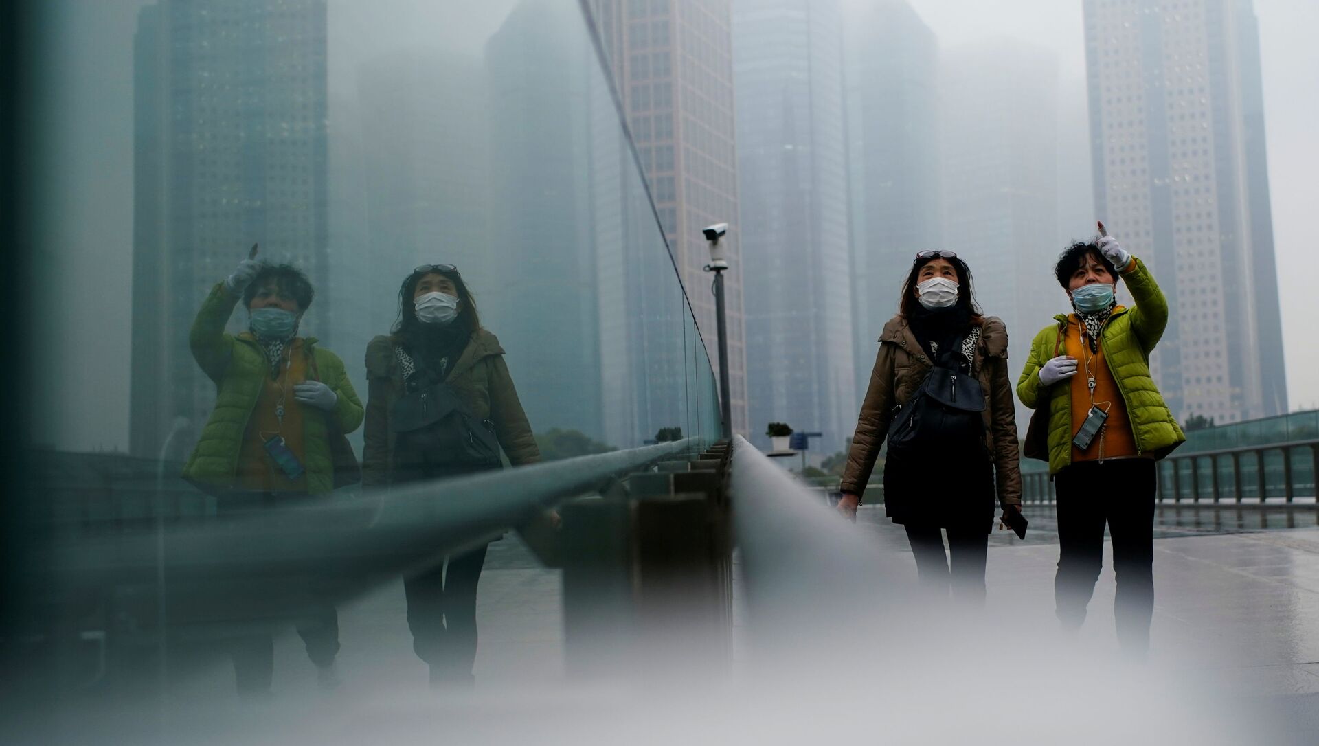 أشخاص يرتدون كمامات يسيرون في أحد الشوارع وسط تفشي مرض فيروس كورونا (كوفيد-19) في شنغهاي الصين، 26 يناير 2021 - سبوتنيك عربي, 1920, 21.06.2021