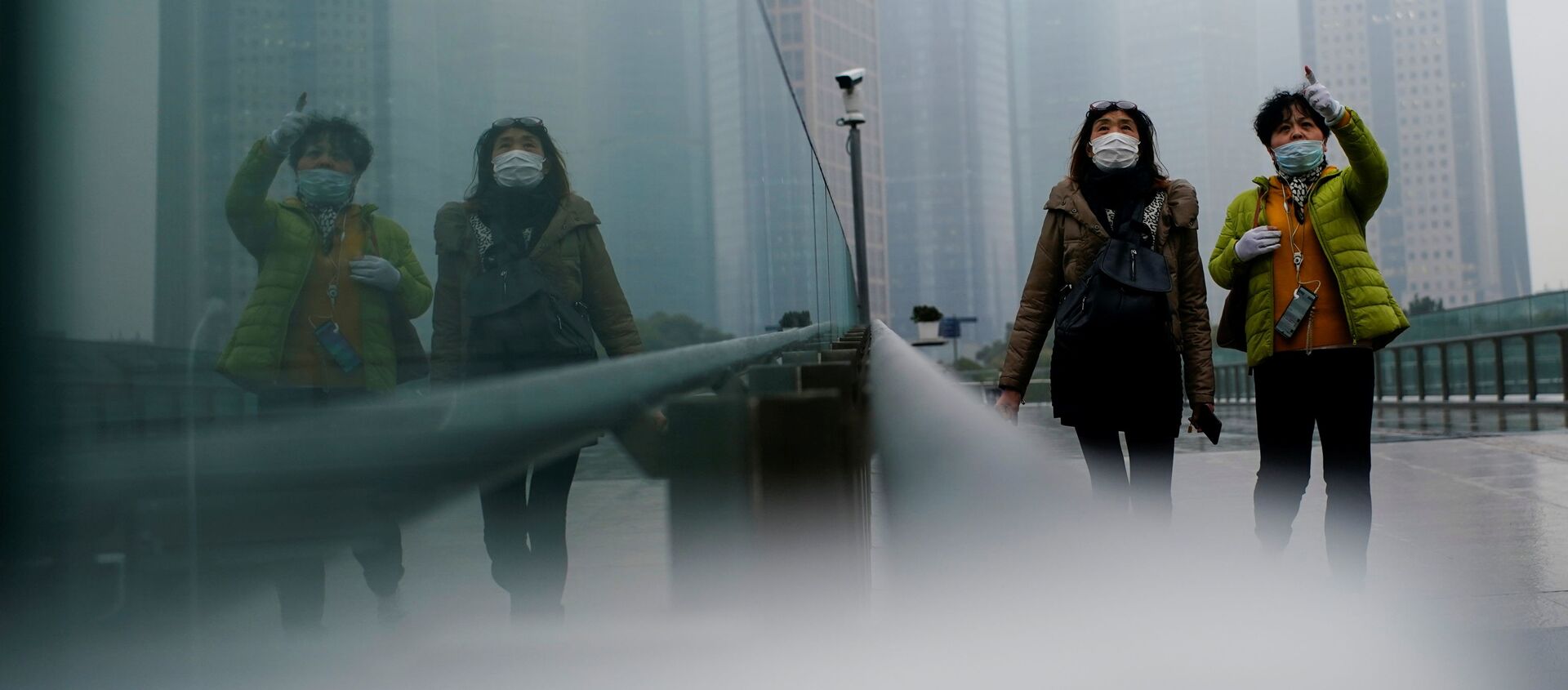 أشخاص يرتدون كمامات يسيرون في أحد الشوارع وسط تفشي مرض فيروس كورونا (كوفيد-19) في شنغهاي الصين، 26 يناير 2021 - سبوتنيك عربي, 1920, 03.07.2021