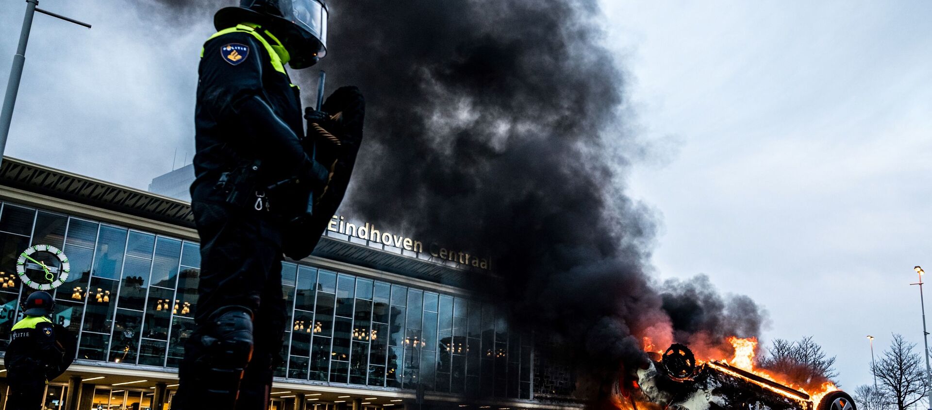 اشتعال النيران في سيارة أمام محطة القطار، بعد احتجاجات من قبل عدة مئات من الأشخاص ضد سياسة كورونا، في أيندهوفن، هولندا 24 يناير 2021  - سبوتنيك عربي, 1920, 20.11.2021