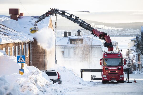 إزالة الجليد من سطح أحد المباني في وسط أورنسكولدسفيك، السويد، 26 يناير 2021 - سبوتنيك عربي