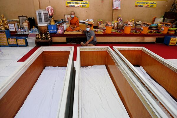 المصلون يستلقون ويصلون داخل توابيت لـ خداع الموت وتحسين حظهم في معبد في بانكوك، تايلاند، 27 يناير 2021 - سبوتنيك عربي
