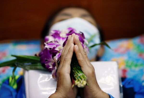المصلون يستلقون ويصلون داخل توابيت لـ خداع الموت وتحسين حظهم في معبد في بانكوك، تايلاند، 27 يناير 2021 - سبوتنيك عربي