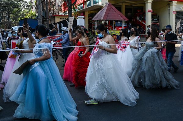 نساء ميانمار يرتدين فساتين الزفاف يحملن لافتات خلال احتجاج ضد الانقلاب العسكري الذي حدث في 1 فبراير/ شباط في العاصمة يانغون، 10 فبراير 2021 - سبوتنيك عربي