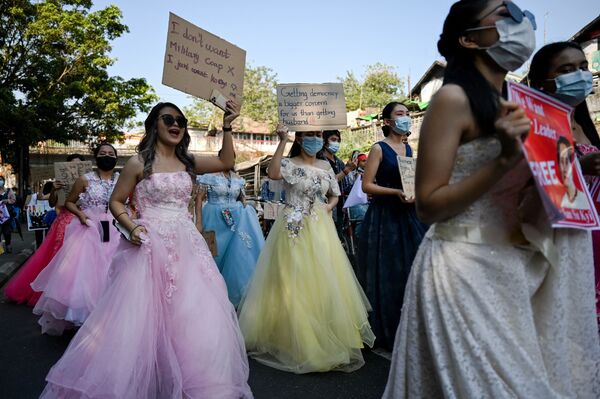 نساء ميانمار يرتدين فساتين الزفاف يحملن لافتات خلال احتجاج ضد الانقلاب العسكري الذي حدث في 1 فبراير/ شباط في العاصمة يانغون، 10 فبراير 2021 - سبوتنيك عربي