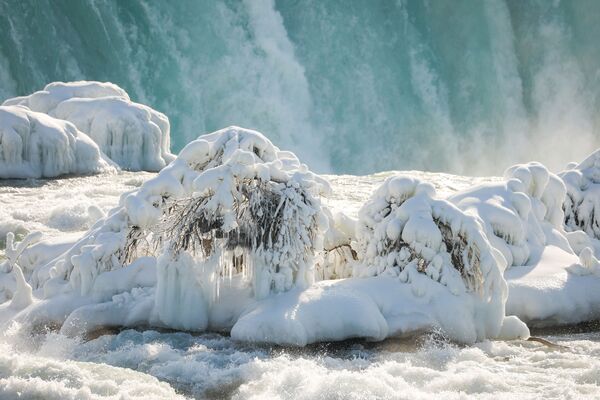 تتدفق المياه حول الجليد الذي تكون في الجزء العلوي من شلالات نياجرا بسبب درجات الحرارة الباردة، ولاية نيويورك، الولايات المتحدة، 21 فبراير 2021 - سبوتنيك عربي