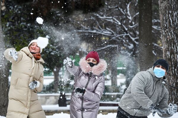 مارة يلعبون بكرات الثلج في أحد شوارع مدينة باكو أثناء تساقط الثلوج الكثيفة في أذربيجان، 24 فبراير 2021 - سبوتنيك عربي