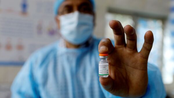 عامل صحي عراقي يعرض لقاح فيروس كورونا المستجد في بغداد، 2 مارس/ آذار 2021 - سبوتنيك عربي