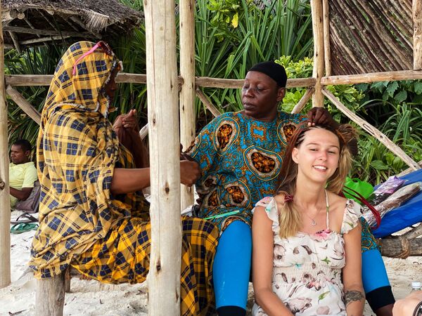 سكان محليون يصنعون االضفائر لفتاة على الشاطئ في جزيرة زنجبار، تنزانيا 18 فبراير 2021 - سبوتنيك عربي