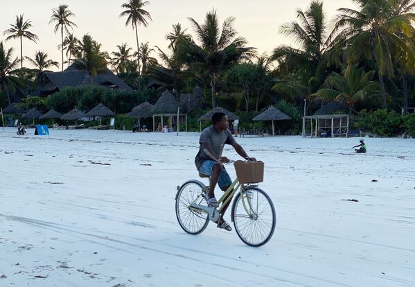 شاب يكرب دراجة على شاطئ جزيرة زنجبار، تنزانيا 18 فبراير 2021 - سبوتنيك عربي