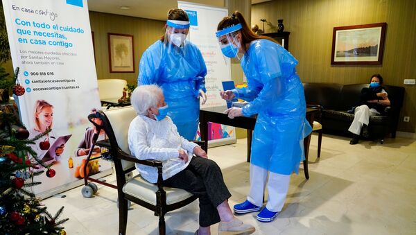 موظفة في دار المسنين إل فيسو تتحدث مع أماليا غونزاليس، 96 عاماً، قبل حقنها بجرعة من لقاح فايزر ضد كوفيد-19 في مدريد، إسبانيا، 7 يناير 2021. - سبوتنيك عربي