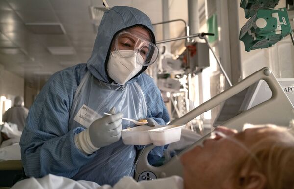 ممرضة تقوم بإطعام مريض في وحدة العناية المركزة بالمستشفى السريري باسم أو. ام. فيلاتوف رقم 15 في موسكو، 8 ديسمبر 2020 - سبوتنيك عربي