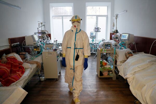 طبيب أثناء تلقي المرضى العلاج في مستشفى للأشخاص المصابين بمرض فيروس كورونا (كوفيد-19) في كييف، أوكرانيا، 26 يناير 2021 - سبوتنيك عربي