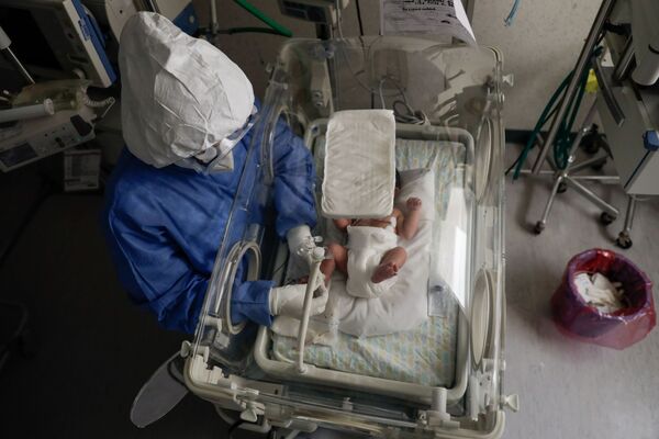 ممرضة تفحص مولودًا جديدًا مصابًا بمرض فيروس كورونا (كوفيد-19)، وهو يرقد في وحدة لحديثي الولادة بفيروس كورونا في مستشفى مونيكا بريتليني ساينز في تولوكا، المكسيك، 4 فبراير 2021 - سبوتنيك عربي