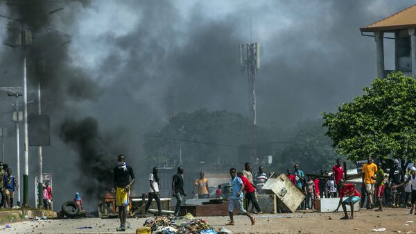 أدخنة في خلفية اشتباكات بين مناصرين ومعارضة في غينيا أكتوبر 2020 - سبوتنيك عربي