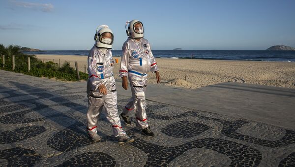 يسير المحاسب تيرسيو غالدينو وزوجته أليسيا، يرتديان ملابس رواد الفضاء، على طول شاطئ إيبانيما في ريو دي جانيرو، كوسيلة للحماية ضد الإصابة بالمرض الفيروسي كوفيد-19، على خلفية تزايد عدد حالات الإصابة في البرازيل، 20 مارس 2021 - سبوتنيك عربي